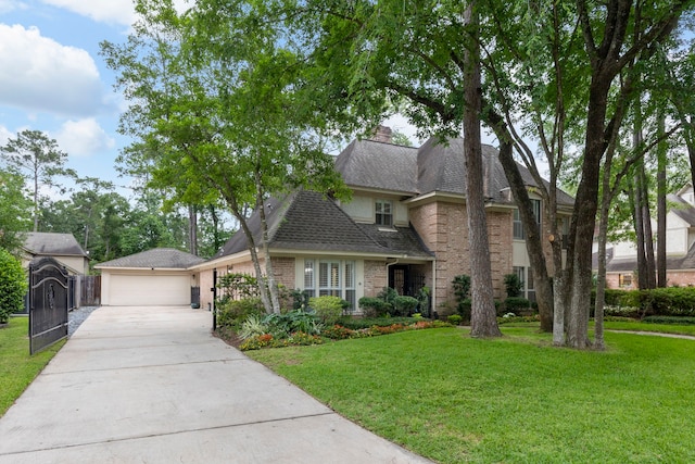 traditional-style home featuring brick siding, a detached garage, a chimney, and roof with shingles