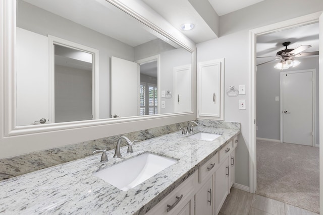 full bath featuring ceiling fan, baseboards, and double vanity