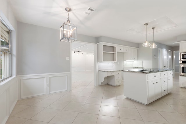 kitchen featuring appliances with stainless steel finishes, white cabinetry, light tile patterned floors, decorative light fixtures, and wainscoting