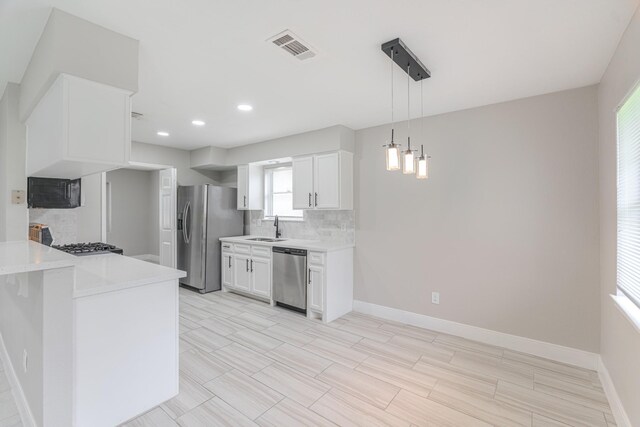 kitchen featuring backsplash, visible vents, a sink, light countertops, and stainless steel appliances