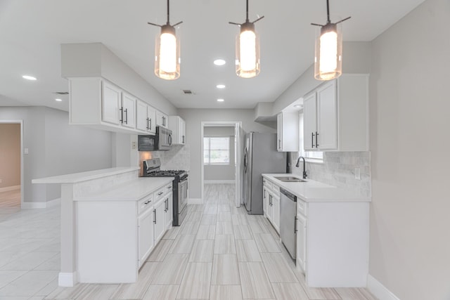 kitchen featuring decorative backsplash, appliances with stainless steel finishes, a sink, baseboards, and light countertops