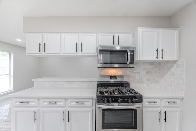 kitchen featuring decorative backsplash, light countertops, stainless steel appliances, recessed lighting, and white cabinetry