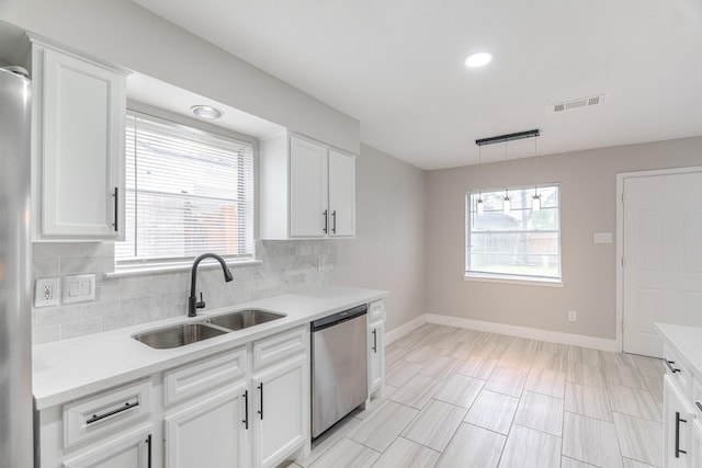 kitchen with a sink, baseboards, decorative backsplash, stainless steel dishwasher, and visible vents