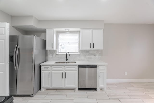 kitchen with decorative backsplash, light countertops, white cabinetry, a sink, and stainless steel appliances