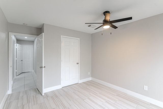 unfurnished bedroom featuring baseboards, ceiling fan, and visible vents