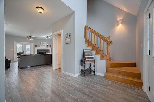 entryway with a ceiling fan, baseboards, wood finished floors, and stairway