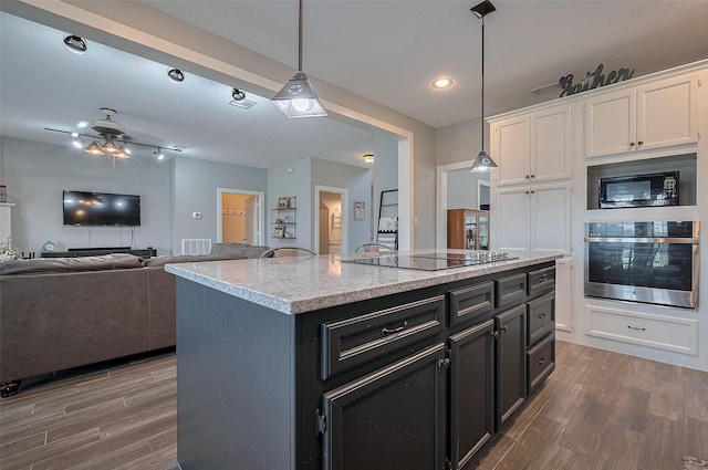 kitchen featuring white cabinets, black appliances, wood finished floors, and decorative light fixtures