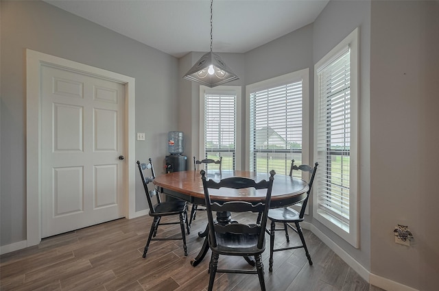 dining space with baseboards and wood finished floors