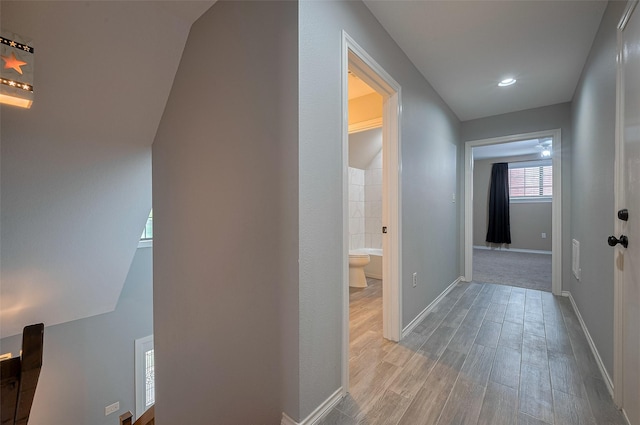hall with baseboards and wood finished floors
