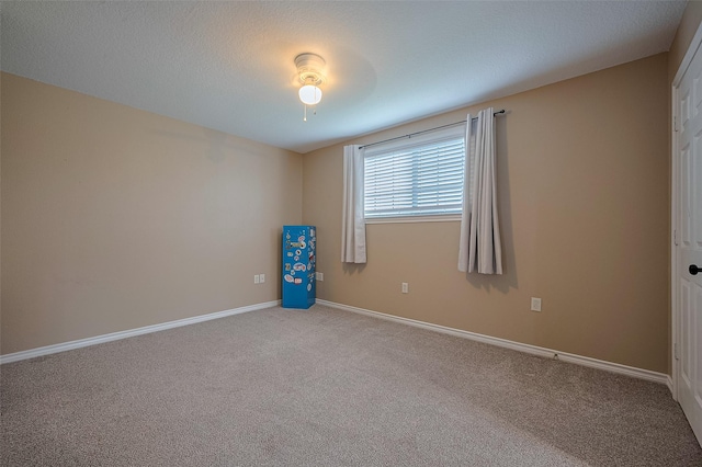 empty room featuring baseboards and carpet
