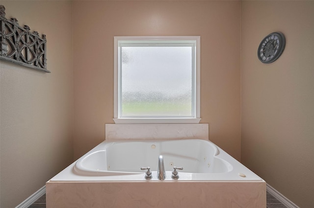 full bath with a tub with jets and baseboards