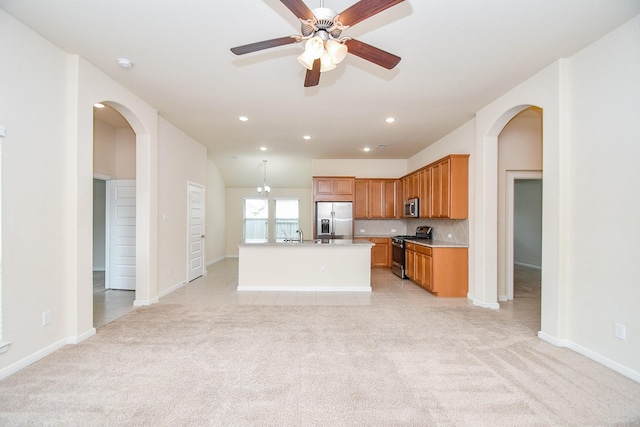 18007 Alora Springs Trce, Cypress, TX 77433 - kitchen with stainless steel appliances, light carpet, arched walkways, light countertops, and ceiling fan