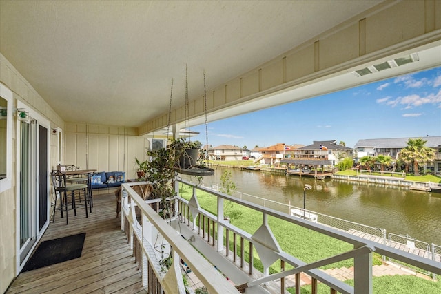 balcony with a water view, visible vents, and a residential view
