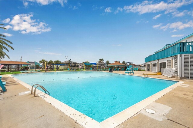 community pool with a patio and fence