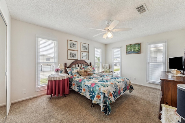 bedroom with visible vents, a ceiling fan, baseboards, a textured ceiling, and carpet flooring