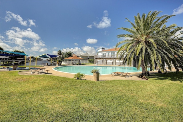 pool featuring a lawn, fence, and a patio