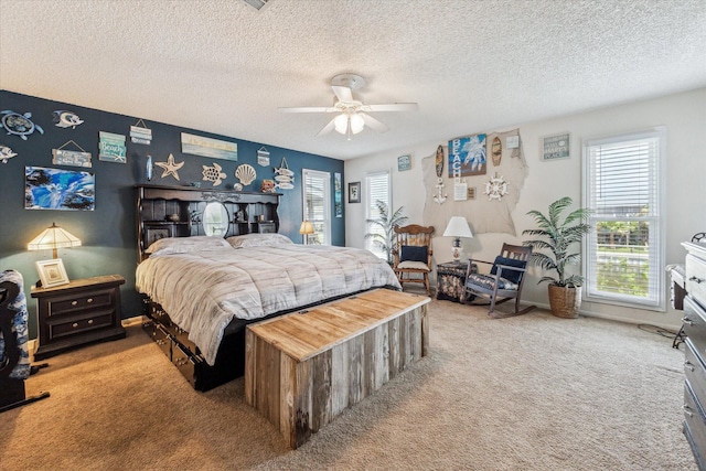 bedroom with a textured ceiling, multiple windows, and carpet