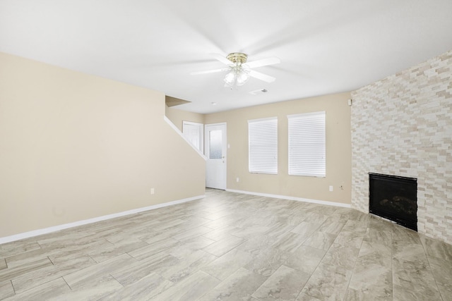 unfurnished living room featuring visible vents, a ceiling fan, baseboards, and a fireplace