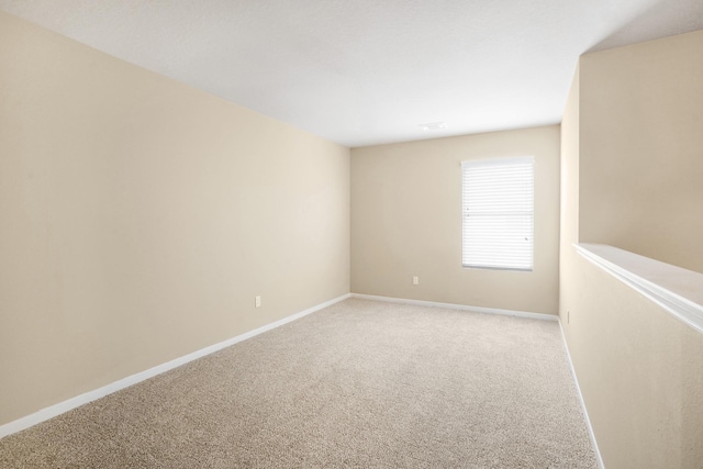 carpeted empty room with baseboards