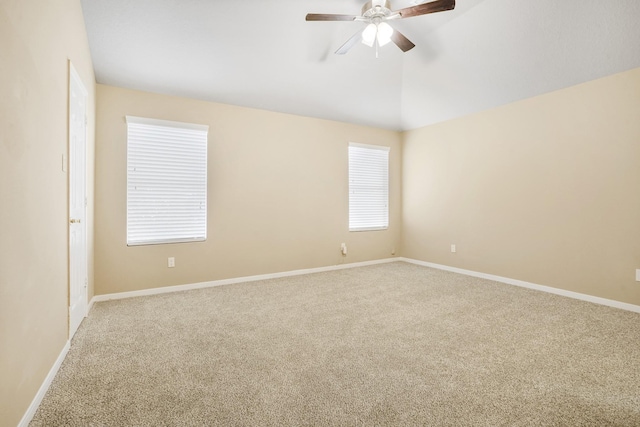 carpeted empty room featuring baseboards, a ceiling fan, and vaulted ceiling