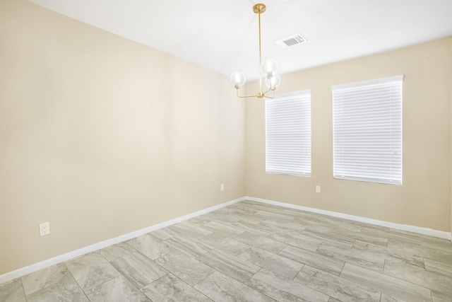 empty room with an inviting chandelier, baseboards, and visible vents