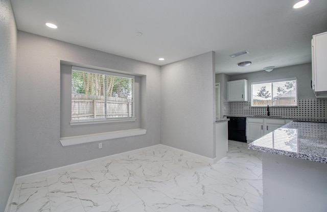kitchen with black dishwasher, baseboards, visible vents, and plenty of natural light