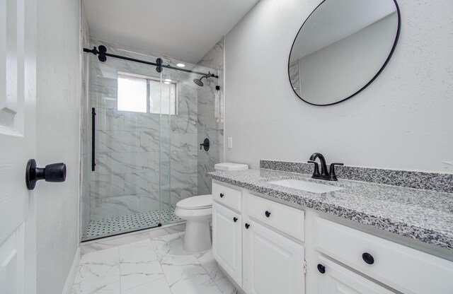 bathroom with vanity, marble finish floor, a marble finish shower, and toilet