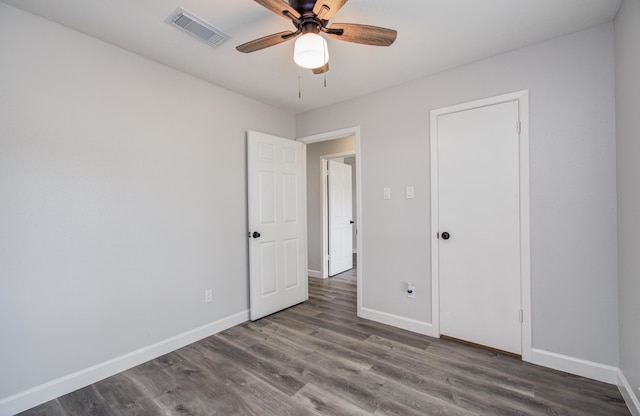 unfurnished bedroom featuring a ceiling fan, baseboards, visible vents, and wood finished floors