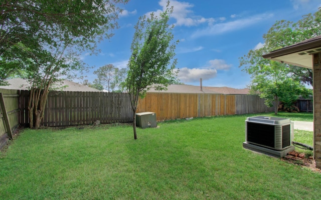 view of yard featuring a fenced backyard and central AC