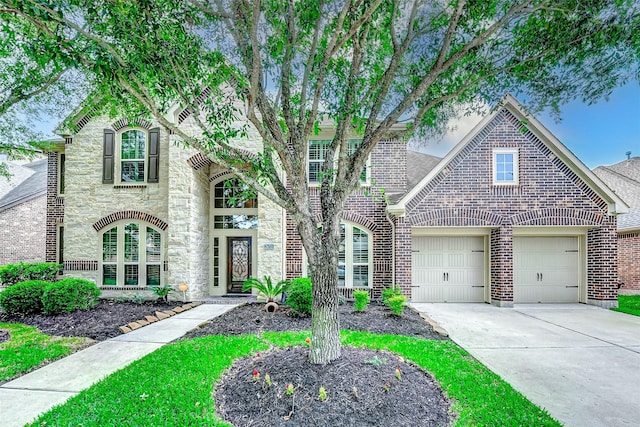 view of front facade featuring concrete driveway, brick siding, an attached garage, and stone siding
