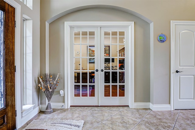 doorway to outside featuring french doors, arched walkways, and tile patterned flooring