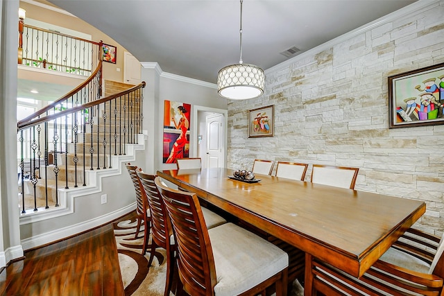 dining area with baseboards, ornamental molding, visible vents, and stairway