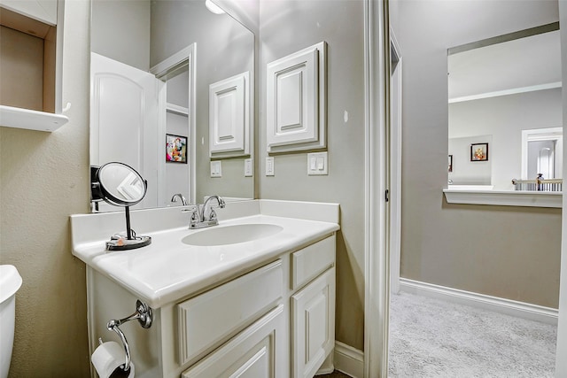 bathroom featuring vanity, baseboards, and toilet