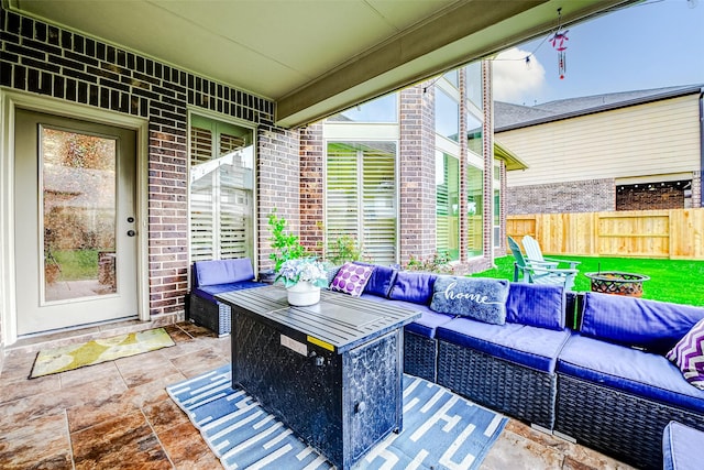view of patio / terrace featuring fence and an outdoor living space with a fire pit