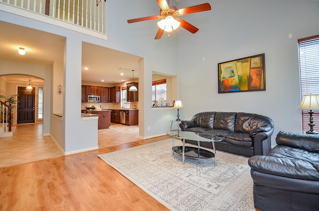 5018 Tramonte Trl, Katy, TX 77494 - living area featuring plenty of natural light, arched walkways, light wood finished floors, and a ceiling fan