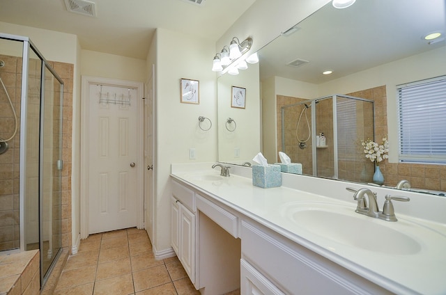 full bathroom with a sink, tile patterned flooring, a stall shower, and visible vents