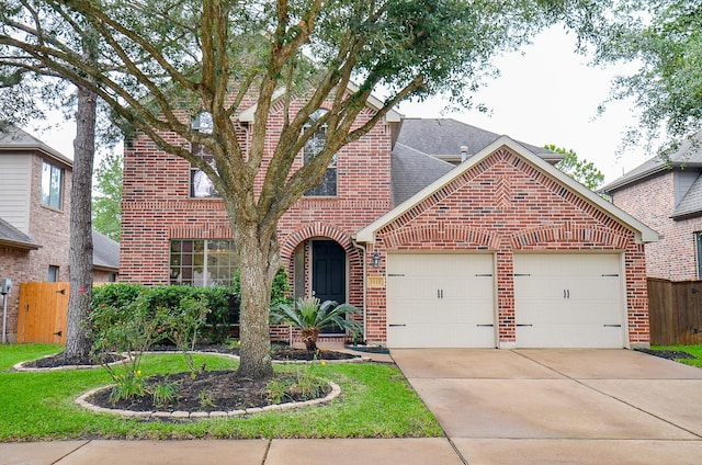 traditional-style house with fence, a shingled roof, brick siding, a garage, and driveway