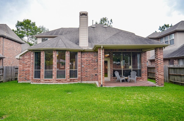 back of house with fence private yard, a patio area, a lawn, and brick siding