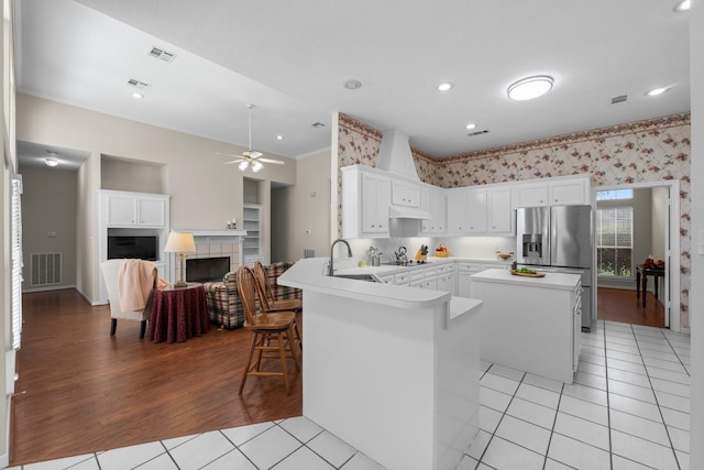 kitchen featuring a sink, stainless steel fridge with ice dispenser, light tile patterned floors, and visible vents
