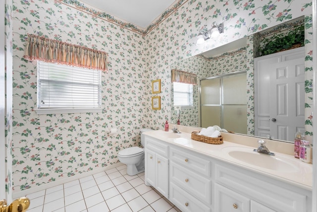 full bath featuring double vanity, wallpapered walls, a shower stall, and a sink