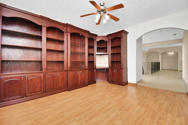 1321 E Archer Rd, Baytown, TX 77521 - unfurnished living room with light wood-style floors, arched walkways, and a ceiling fan