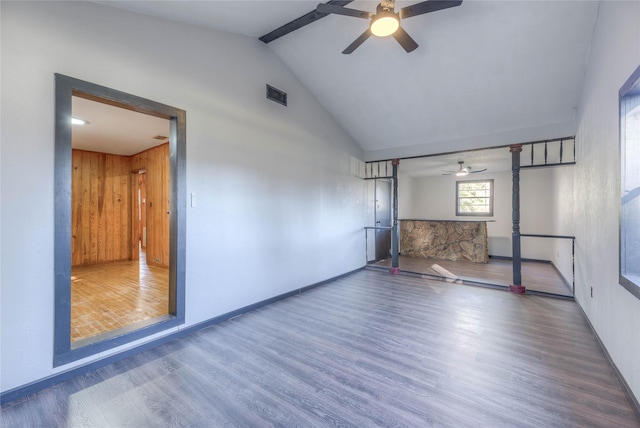 unfurnished room featuring visible vents, lofted ceiling, wood finished floors, baseboards, and a ceiling fan