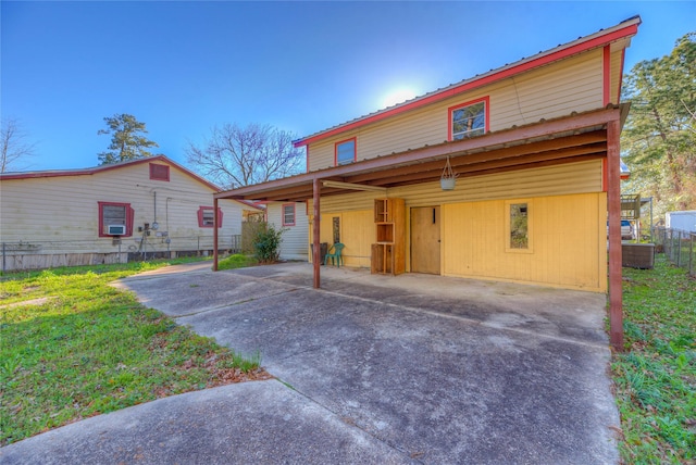 view of front of property featuring fence, driveway, and metal roof