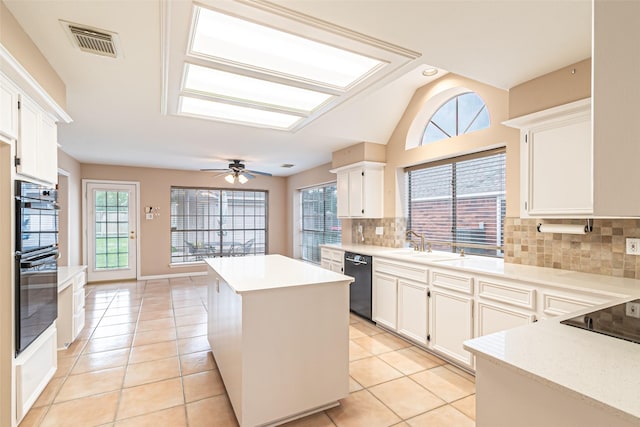 kitchen featuring backsplash, visible vents, a center island, a sink, and black appliances