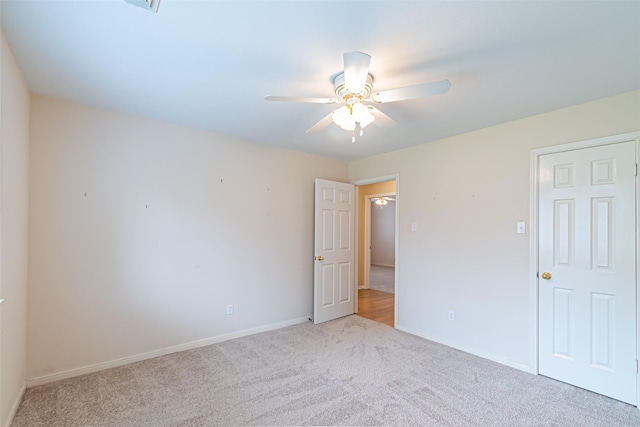 unfurnished bedroom featuring baseboards, a ceiling fan, and carpet