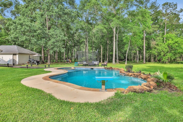 view of pool featuring a pool with connected hot tub, a diving board, and a yard