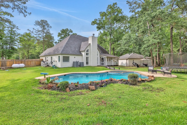 view of pool with a fenced backyard, an outbuilding, cooling unit, a patio, and a yard