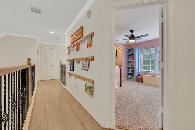 corridor with crown molding, visible vents, light wood-style floors, baseboards, and recessed lighting