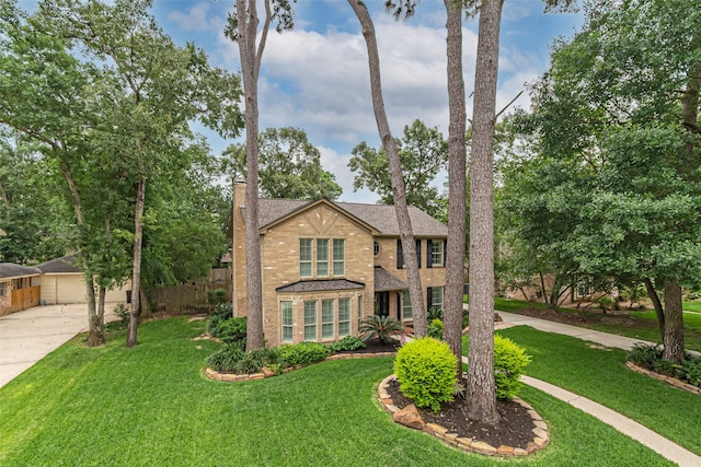 view of front facade with concrete driveway, brick siding, a chimney, and a front lawn