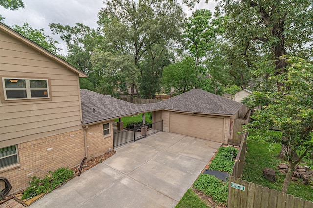 view of front of home with a garage, roof with shingles, fence, and driveway